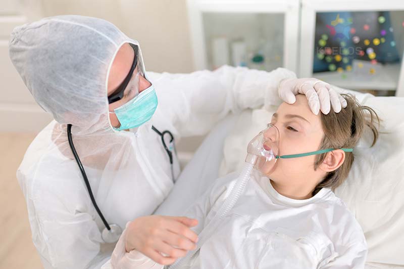 Empathic female doctor treats and intubating a child with respiratory virus