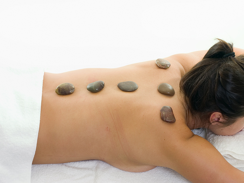 terapia goracymi kamieniami umiejscowionymi na plecach kobiety